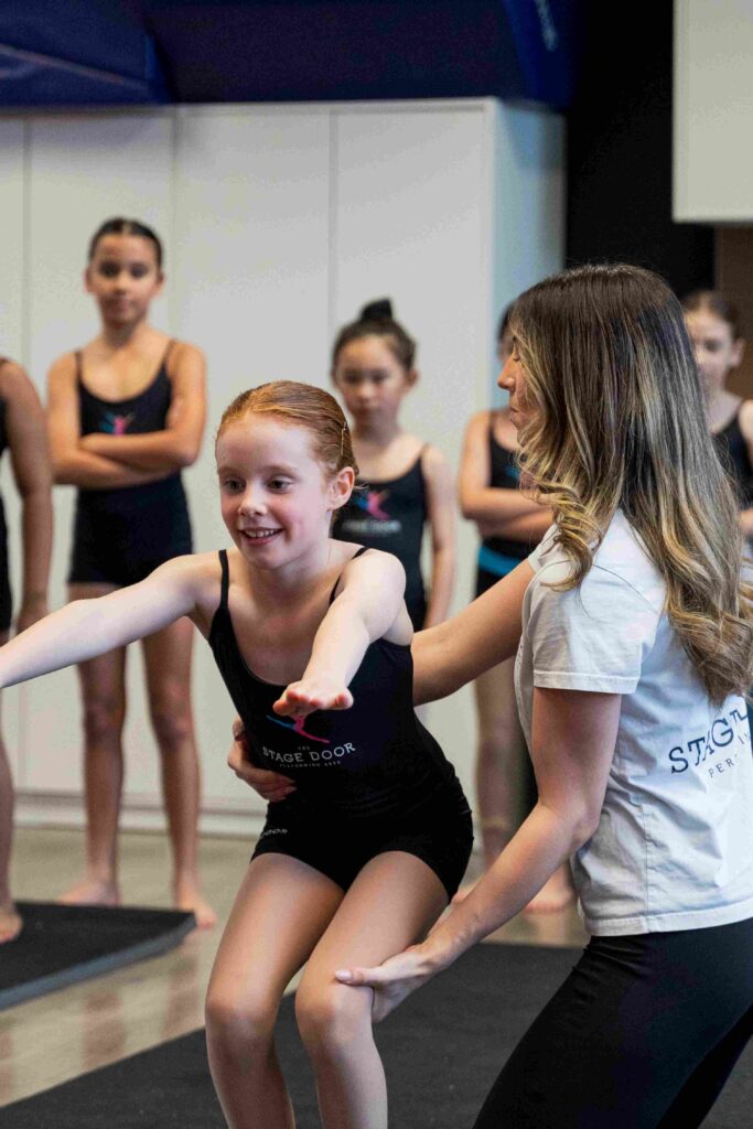 Acrobatics instructor correcting student's form